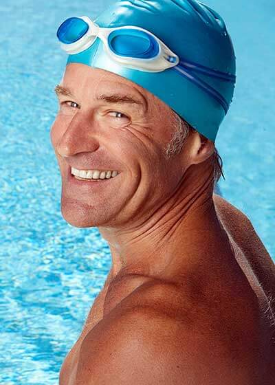 A Rye Brook white man swimming with custom hearing aids
